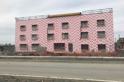 Image of a 3-story building under construction, with a 3M™ Air Barrier applied