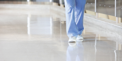 doctor walking through the hallway on a sparkling clean hospital floor
