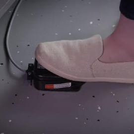 Video still of a worker depressing the foot control to dispense adhesive