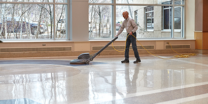 man buffing floor with 3M floor care products
