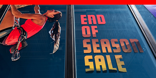 Large window graphic showing rock climber and advertising sale.
