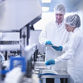 Two Scientists standing at a testing device