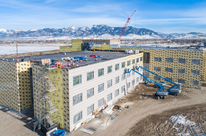 Winter image of a building complex: buildings are wrapped with 3M air barrier and exterior cladding is applied to one side
