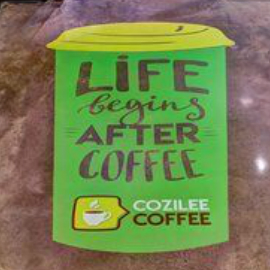 Green floor graphic in shape of coffee cup reading, “Life begins after coffee.”