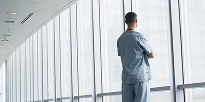 man looking out clean facility window
