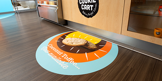 Cookie shop with colorful floor wrap with images of cookies.
