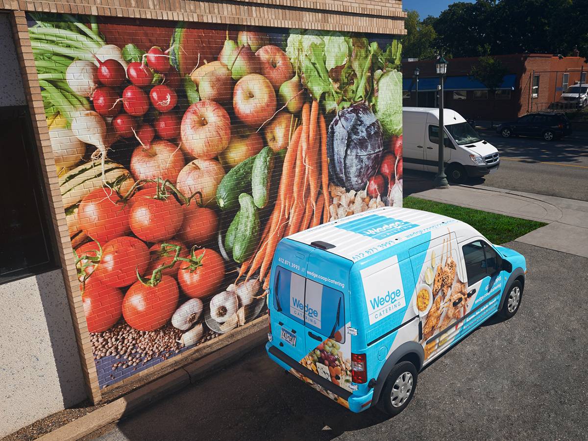 Grocery exterior wall and van with promotional graphics
