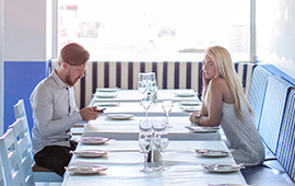 couple sitting at a restaurant table with no other patrons around them.
