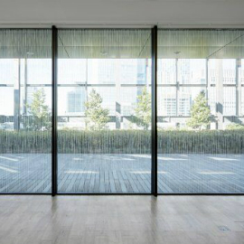 Three floor-to-ceiling windows with 3M™ Fasara™ Glass Finishes looking out onto a courtyard.