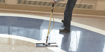 Worker using 3M Floor Care System to clean floor in commercial building.
