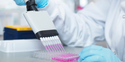 Person using a tool in a lab to transfer liquid
