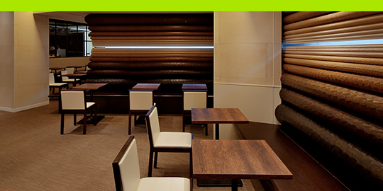 Retail space with tables and walls in a wood-grain surface.

