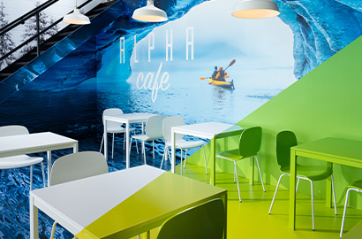 A café with a large graphic wall wrap showing kayakers in the sea with a cave.