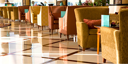 Long row of paired wing chairs with shiny, patterned floor underneath.

