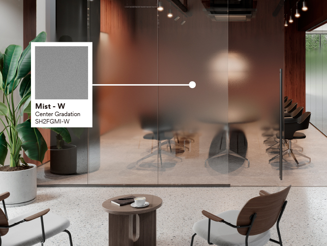 An office worker walks behind glass surfaces with 3M glass finishes whose attractive patterns create privacy.
