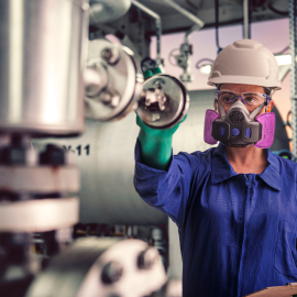 在化工厂佩戴 PPE 作业的工人